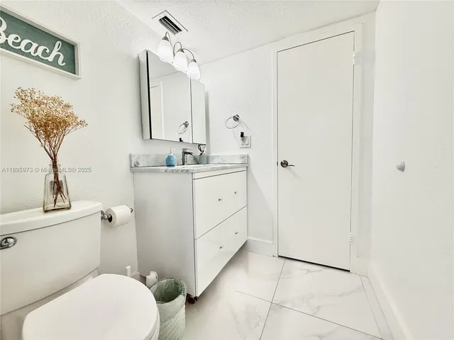 a bathroom with a granite countertop sink and mirror