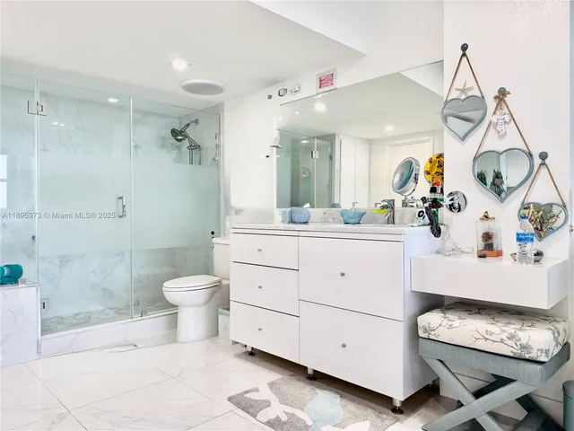 a spacious bathroom with a double vanity sink a mirror and a toilet