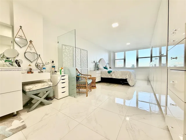 a living room with flat screen tv on the dresser and a flat screen tv