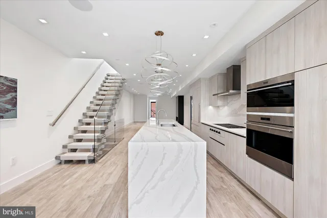 a large white kitchen with stainless steel appliances