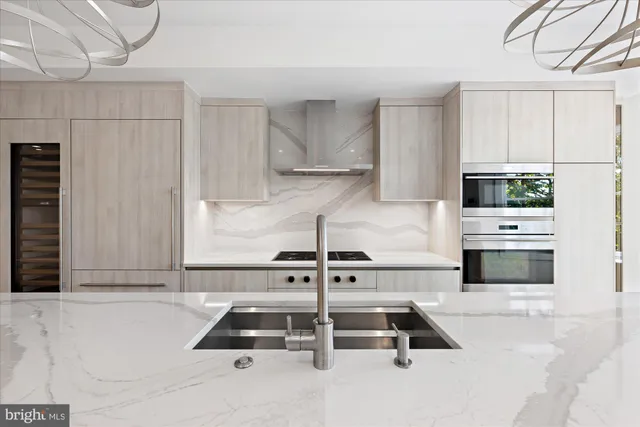 a kitchen with kitchen island a stove and a refrigerator with white cabinets