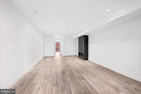 a view of an empty room with wooden floor