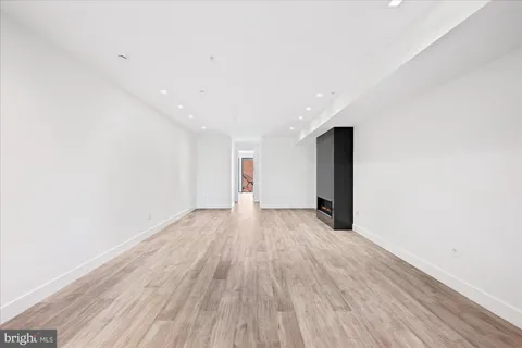 a view of a big room with wooden floor and natural light