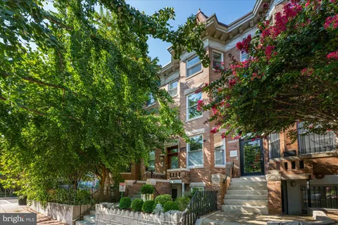 a front view of a house with a tree