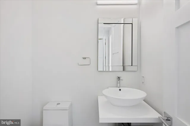 a bathroom with a sink a mirror and a toilet
