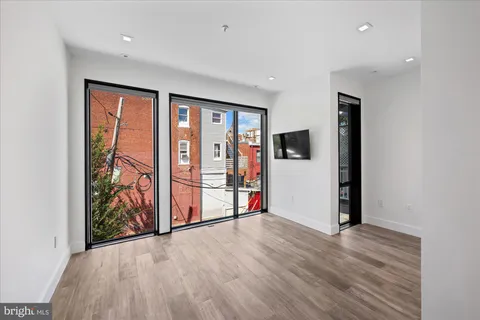 an empty room with wooden floor and entryway