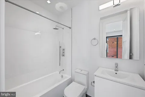 a bathroom with a toilet sink a mirror and shower