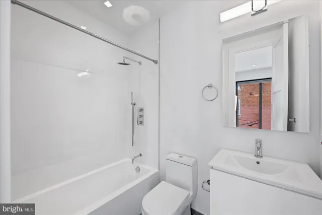 a bathroom with a toilet sink a mirror and shower