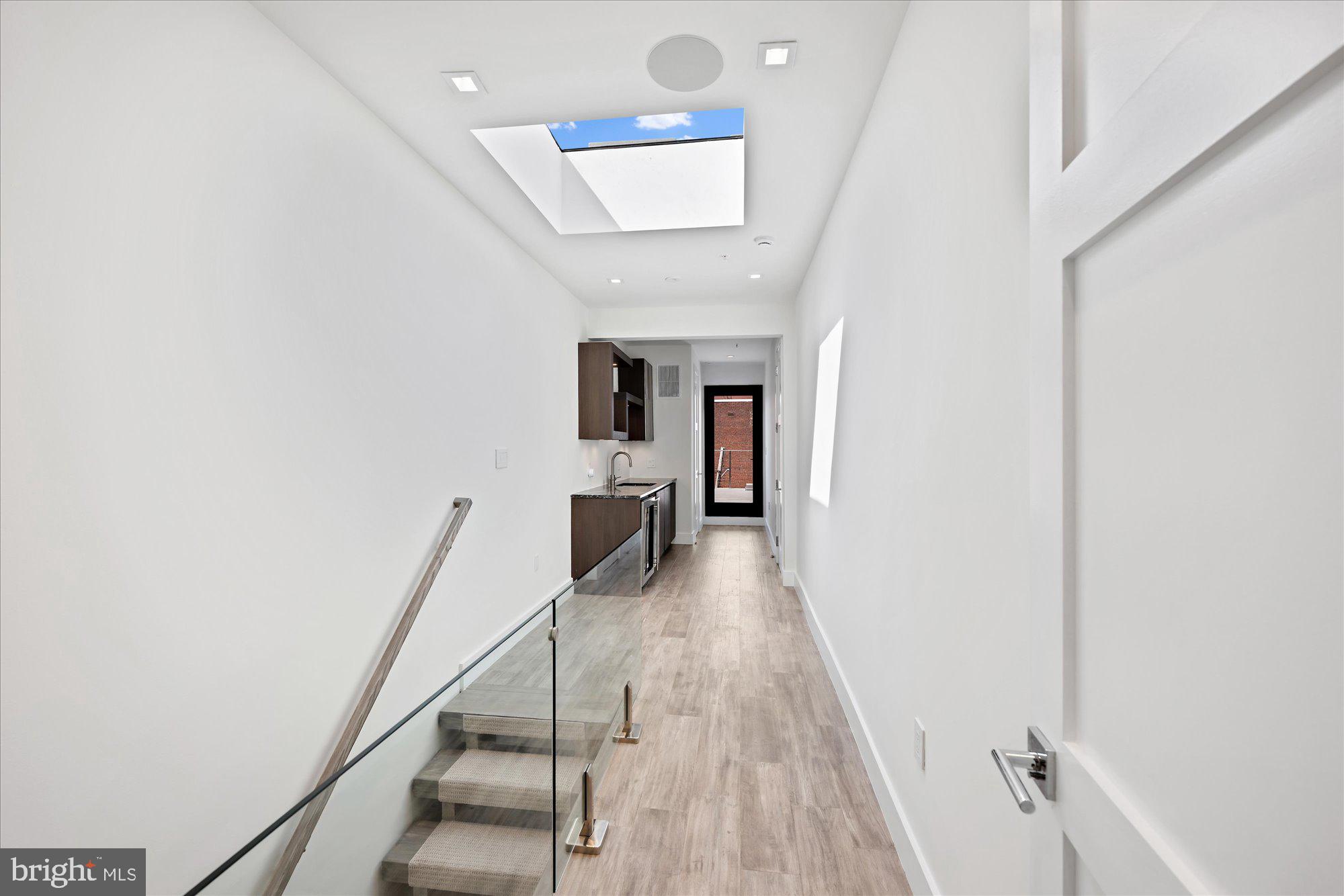 1777 T Street Northwest, Unit 5 Washington, DC 20009 - Photo 29 of 48 a hallway with wooden floor staircase and a kitchen view