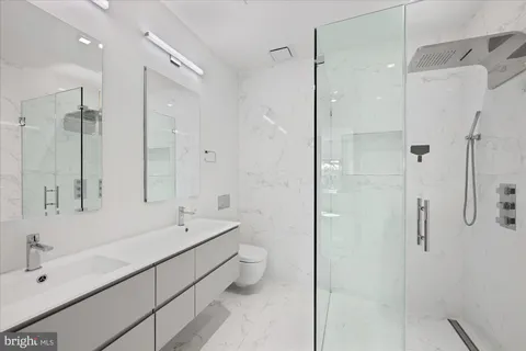 a bathroom with a double vanity sink mirror and shower
