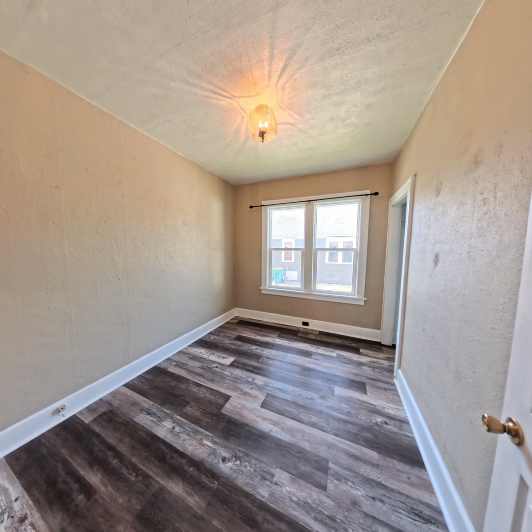 118 West 3rd Street Streator, IL 61364 - Photo 12 of 29 a view of an empty room with wooden floor and a window