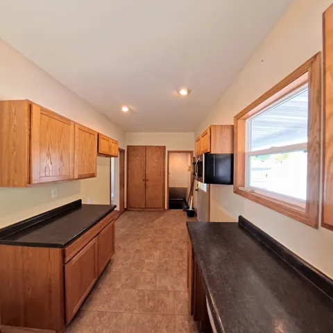 a large kitchen with stainless steel appliances granite countertop a sink and a stove