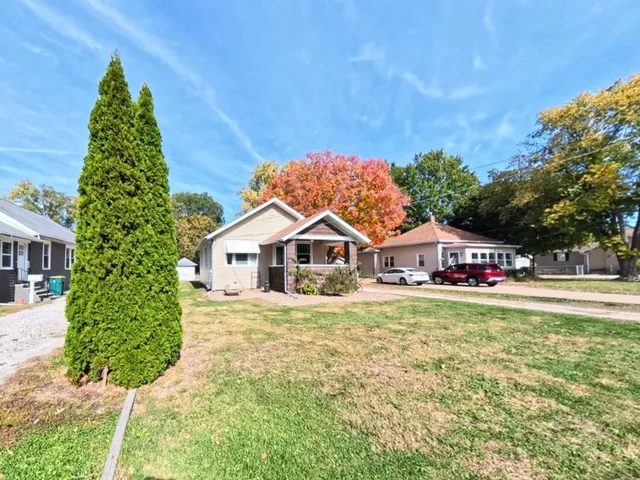 a front view of a house with a yard and trees