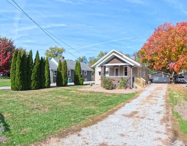 a front view of a house with a yard and trees