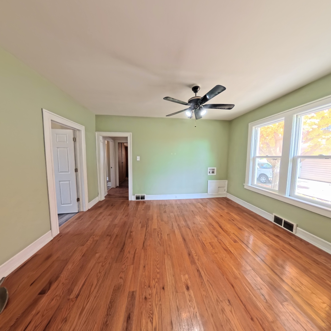 118 West 3rd Street Streator, IL 61364 - Photo 8 of 29 a view of an empty room with wooden floor and a window