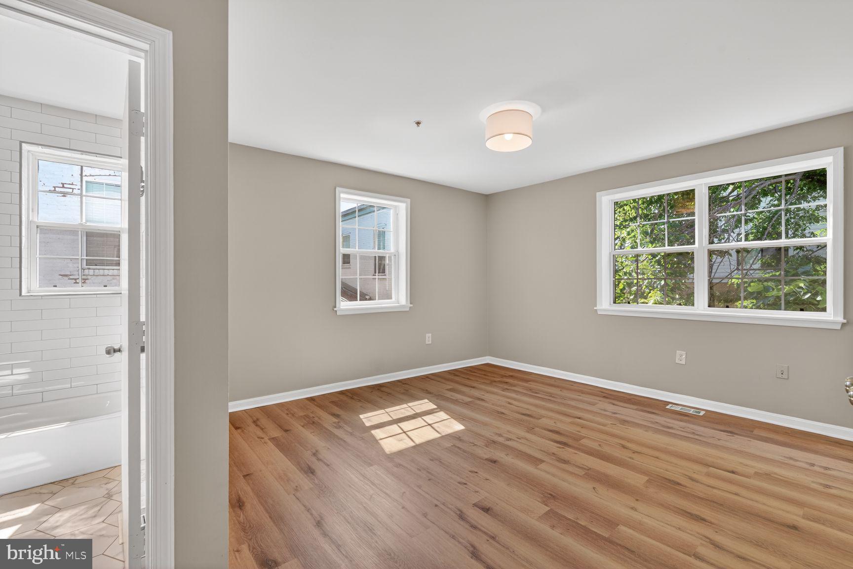 1008 Rittenhouse Street Northwest, Unit 15 Washington, DC 20011 - Photo 33 of 39 an empty room with wooden floor and windows