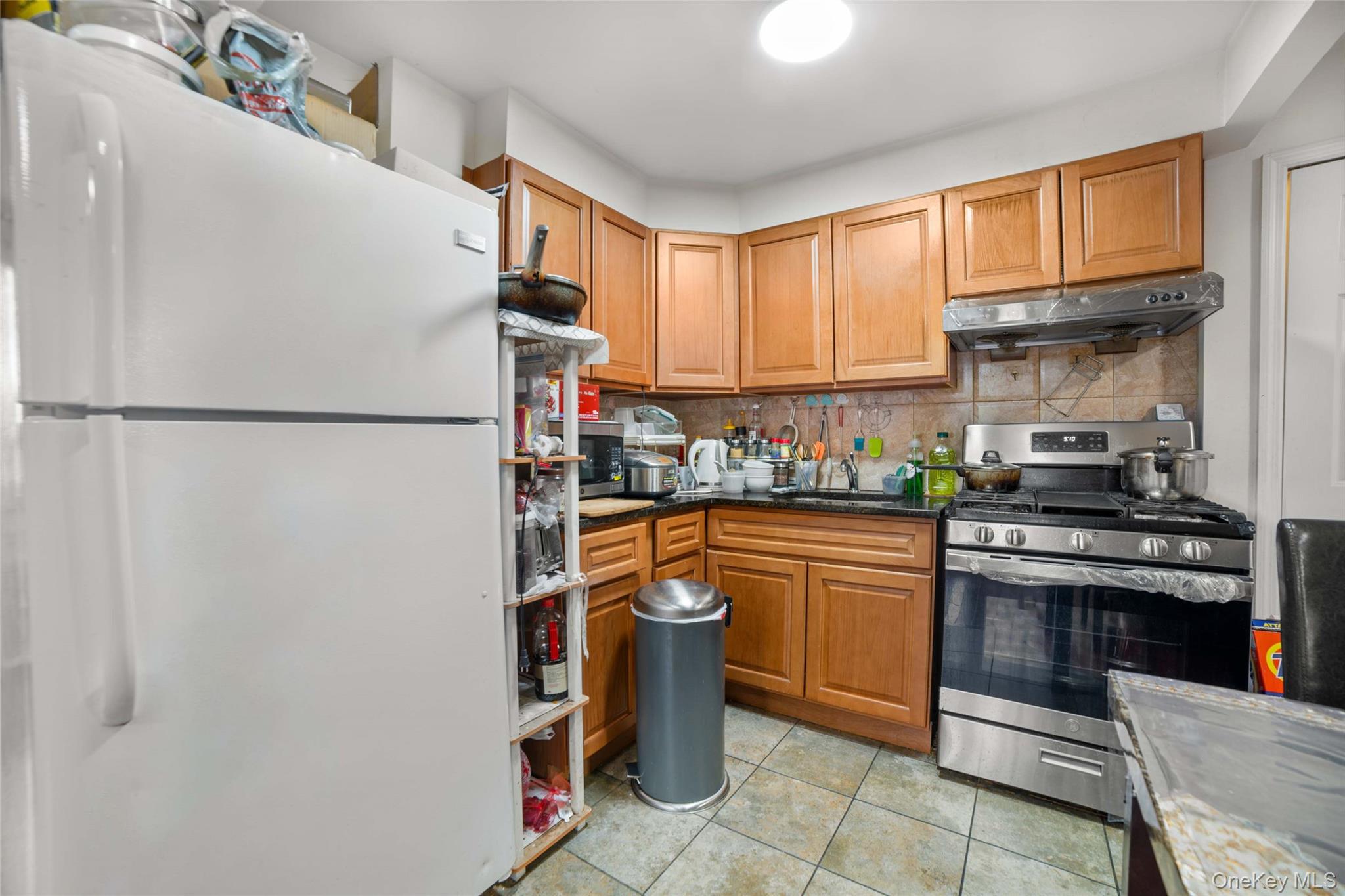 58-04 Main Street, Unit 1A Queens, NY 11355 - Photo 8 of 21 a kitchen with stainless steel appliances granite countertop a refrigerator sink stove and cabinets