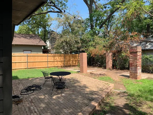 a view of a backyard with a bench and plants