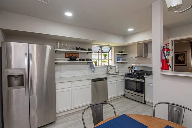 a kitchen with stainless steel appliances granite countertop a refrigerator sink and stove