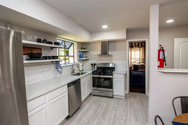 a kitchen with stainless steel appliances granite countertop a refrigerator and a sink