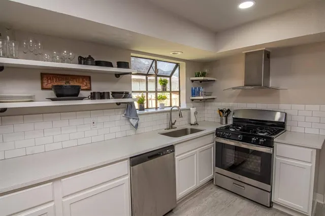 a kitchen with stainless steel appliances granite countertop a sink and a stove