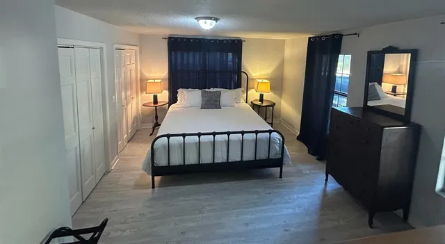 a bedroom with a bed and wooden floor