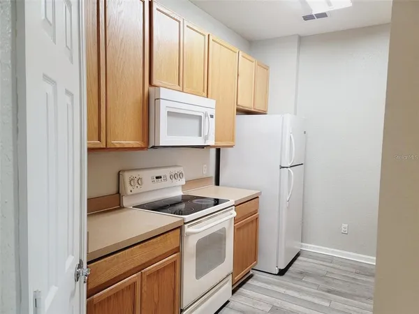 a kitchen with a refrigerator sink and cabinets