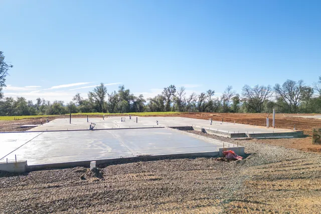 a view of a lake with a yard and large trees