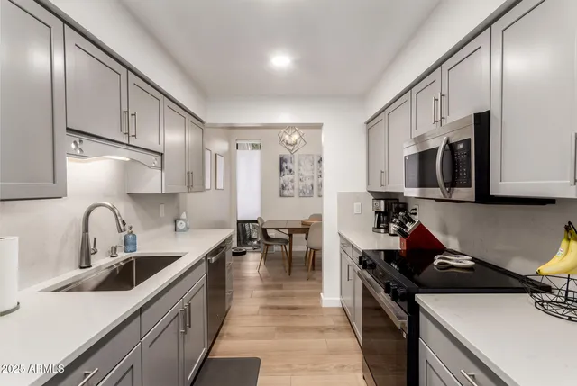 a kitchen with stainless steel appliances a refrigerator sink and stove
