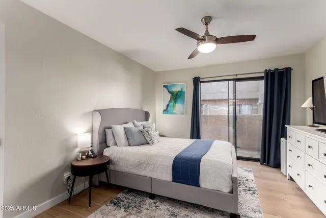 a bedroom with a large bed and flat tv screen on dresser