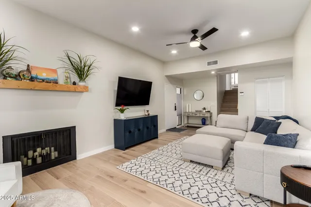 a living room with furniture a large window and a fireplace