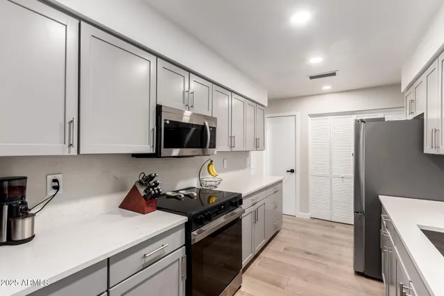 a kitchen with stainless steel appliances a sink stove and cabinets