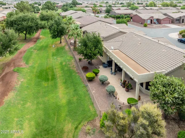 an aerial view of residential houses with outdoor space and trees all around