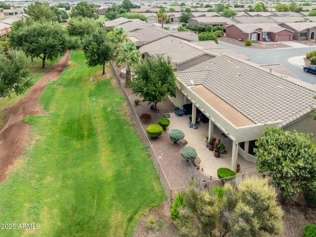 an aerial view of residential houses with outdoor space and trees all around