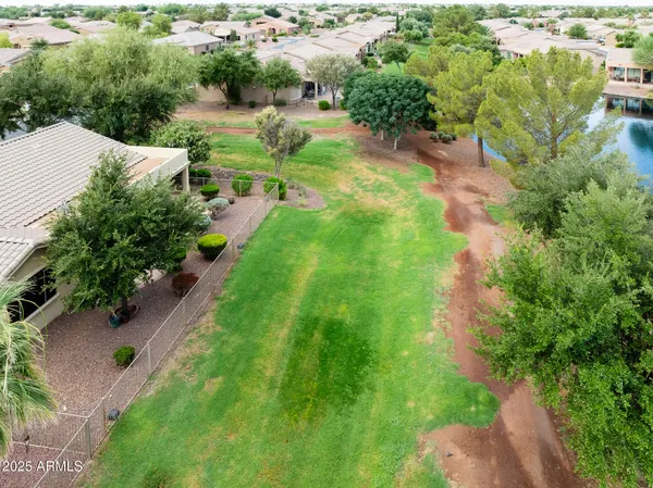 an aerial view of residential house with outdoor space and trees all around