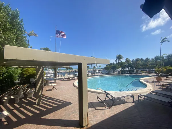 a view of a swimming pool with outdoor seating and a yard