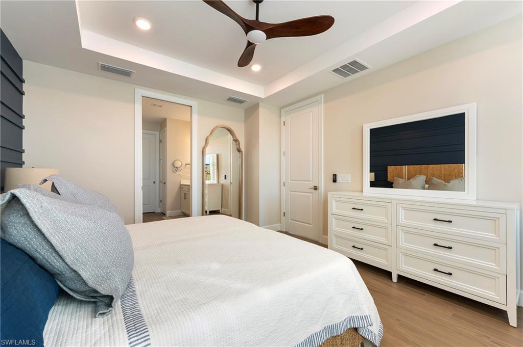 11929 Sacra Place Fort Myers, FL 33913 - Photo 17 of 50 a bedroom with a large bed and a flat tv screen on dresser