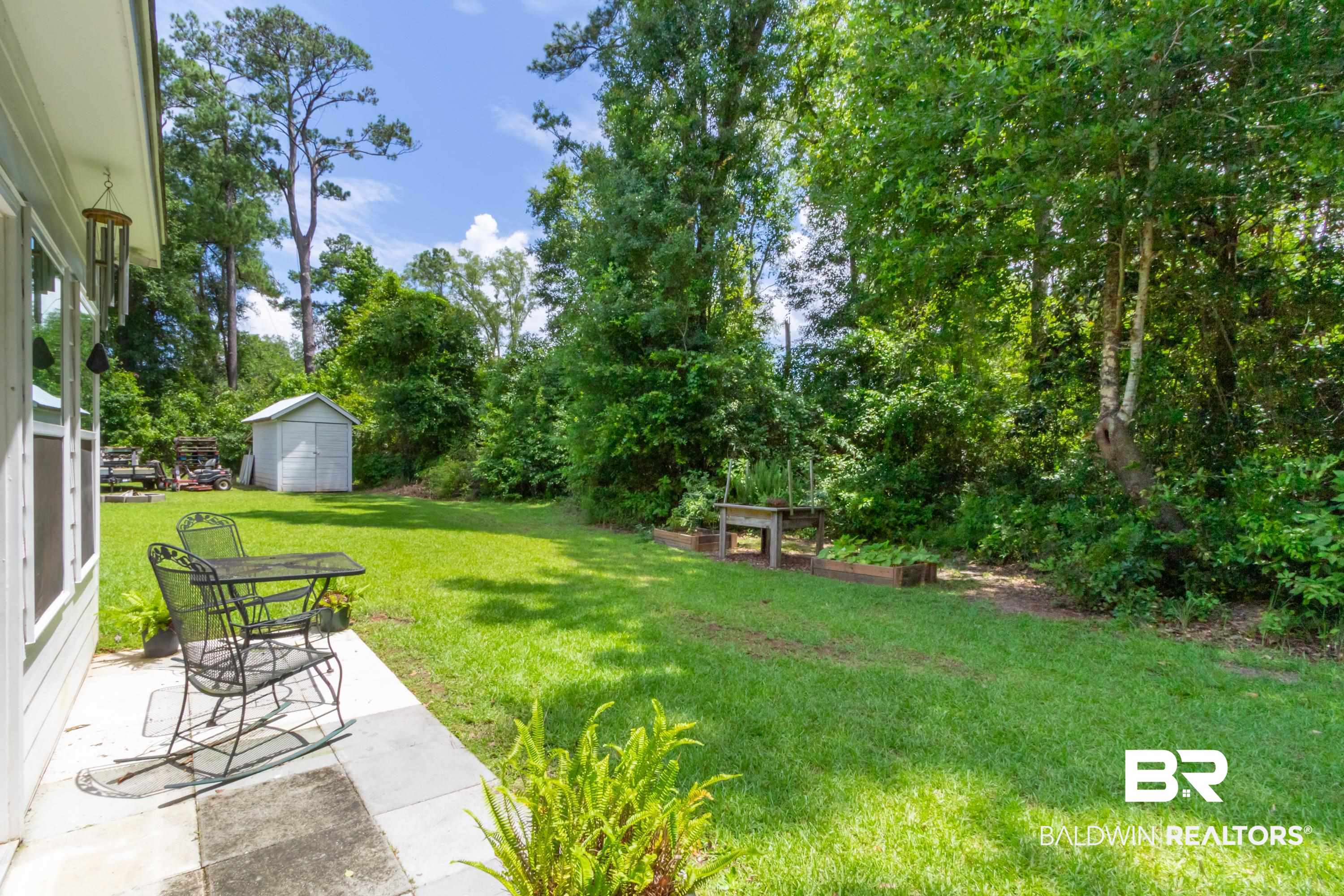 7472 Coopers Landing Road Foley, AL 36535 - Photo 34 of 40 Expansive backyard featuring a manicured lawn, established trees, and a white storage shed