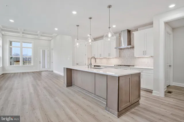 a kitchen with kitchen island granite countertop a sink cabinets and stainless steel appliances