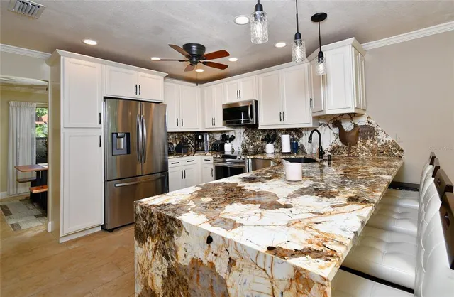 a kitchen with stainless steel appliances a refrigerator sink and microwave