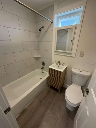a bathroom with a sink a toilet a mirror and shower