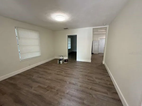 an empty room with wooden floor and closet