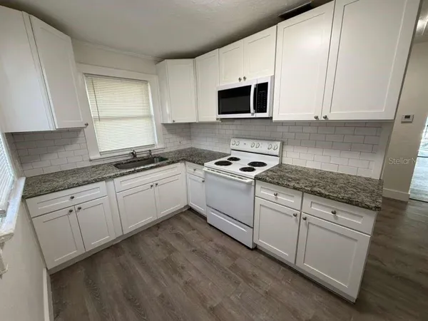 a kitchen with granite countertop cabinets stainless steel appliances and sink