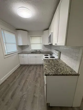 a kitchen with stainless steel appliances granite countertop a sink stove and cabinets