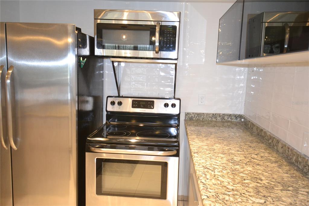 2585 Countryside Boulevard, Unit 4307 Clearwater, FL 33761 - Photo 14 of 32 a kitchen with a stove and a microwave