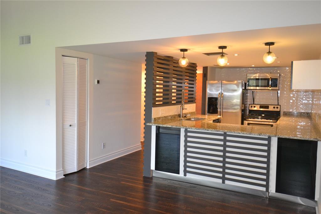 2585 Countryside Boulevard, Unit 4307 Clearwater, FL 33761 - Photo 15 of 32 a view of a living room and kitchen with furniture and wooden floor