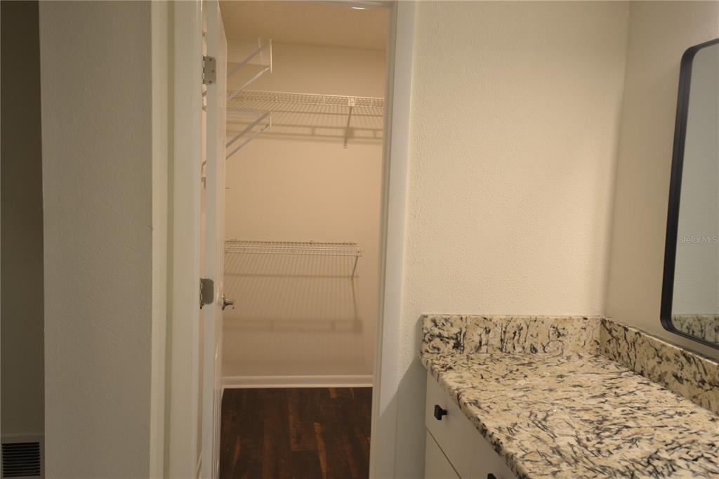 2585 Countryside Boulevard, Unit 4307 Clearwater, FL 33761 - Photo 26 of 32 a bathroom with a granite countertop sink and a mirror