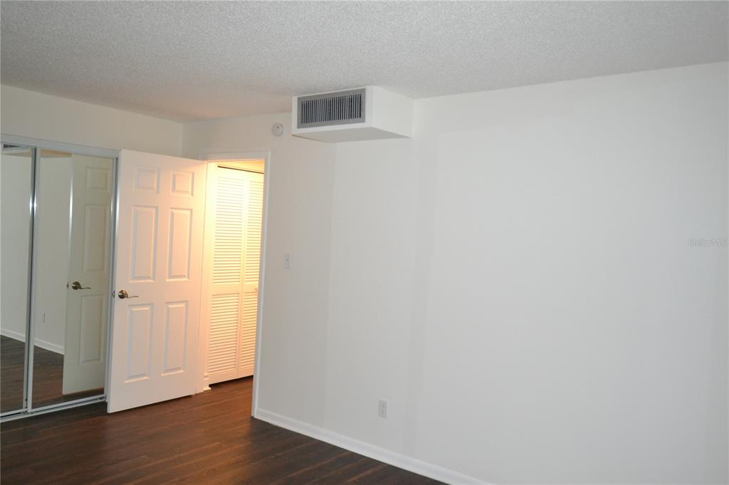 2585 Countryside Boulevard, Unit 4307 Clearwater, FL 33761 - Photo 4 of 32 an empty room with wooden floor and windows