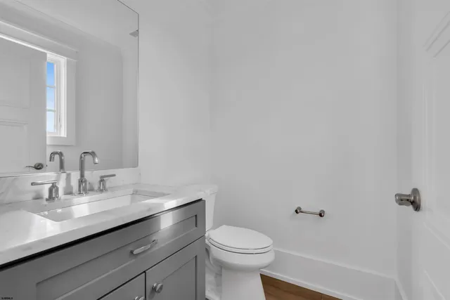 a living room with stainless steel appliances furniture a fireplace a flat tv screen and a wooden floor