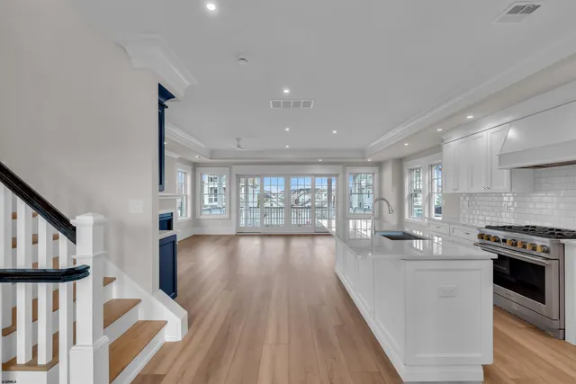 a large kitchen with stainless steel appliances granite countertop a lot of counter space and wooden floors